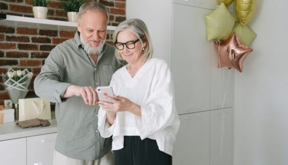 Two Elderly Individuals Looking at Phone