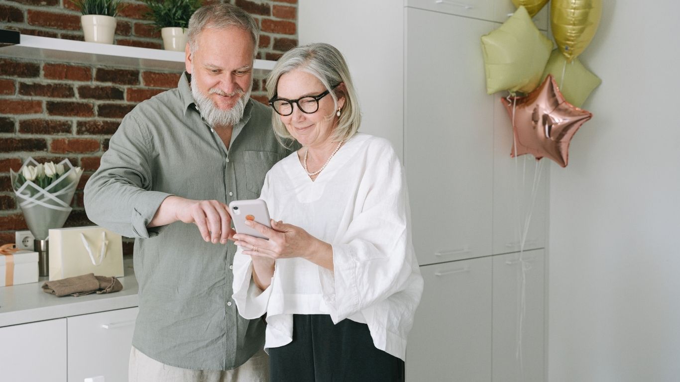 Two Elderly Individuals Looking at Phone